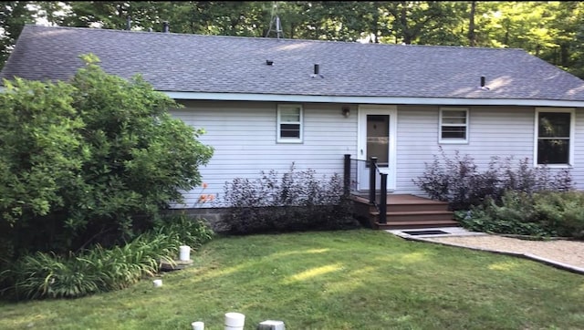 view of front of home with a front lawn and a shingled roof