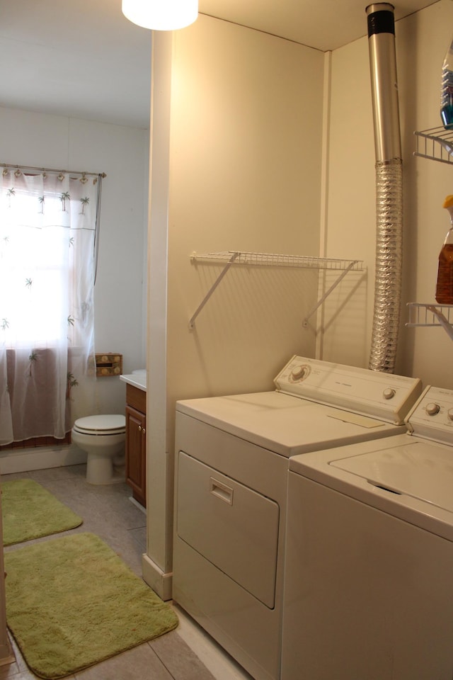 laundry room with washing machine and dryer, laundry area, and light tile patterned floors