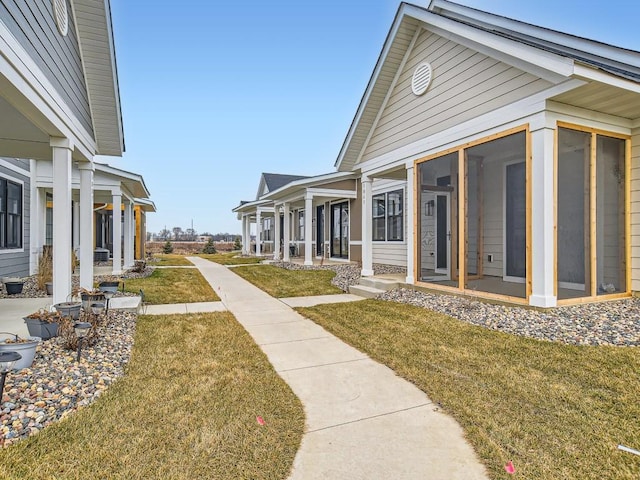 view of home's exterior with a yard and a sunroom