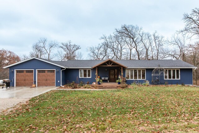 single story home with covered porch, driveway, an attached garage, and a front yard