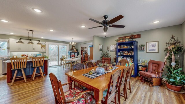 dining area featuring light wood finished floors, ceiling fan with notable chandelier, and recessed lighting