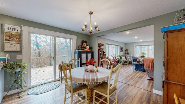 dining area with baseboards, wood finished floors, and a notable chandelier