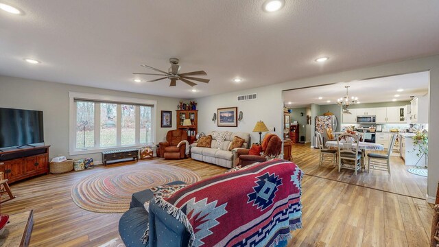 living room featuring light wood-style flooring, visible vents, and recessed lighting