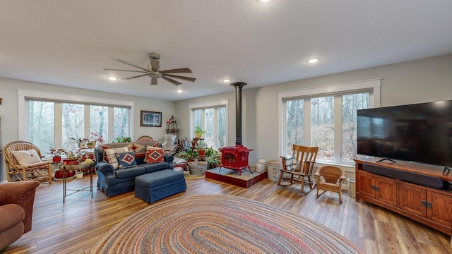 living area featuring a wood stove, light wood finished floors, and plenty of natural light