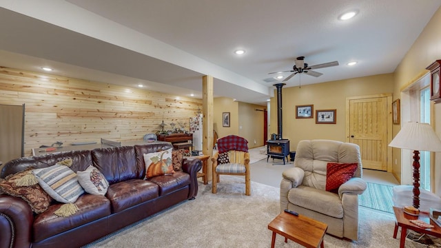 living area with a wood stove, wood walls, carpet floors, and recessed lighting