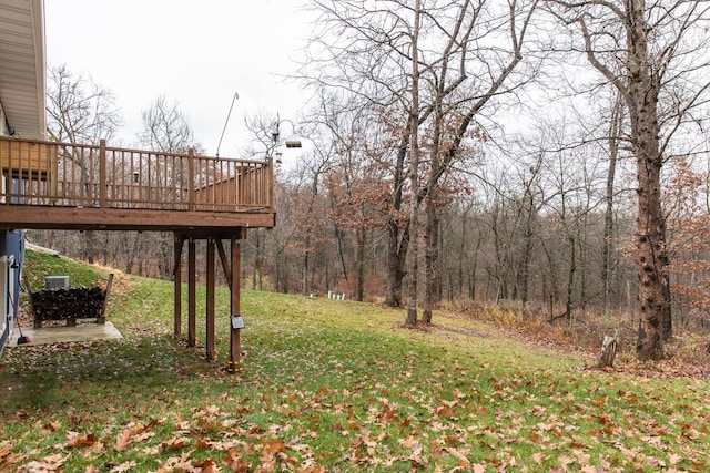 view of yard featuring a forest view and a deck