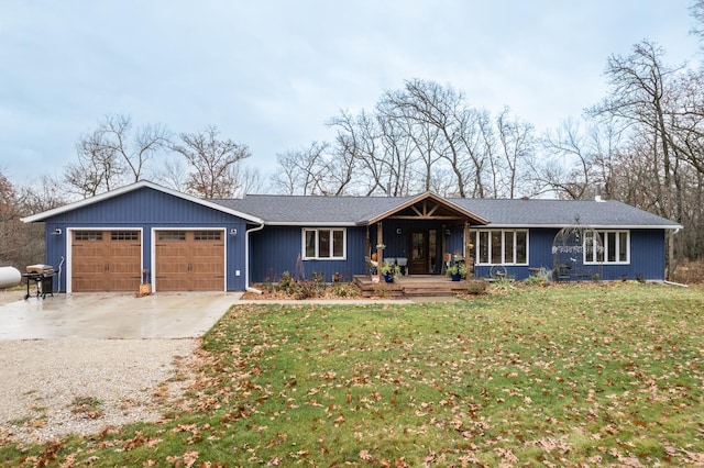 ranch-style home featuring a garage, a front yard, concrete driveway, and covered porch