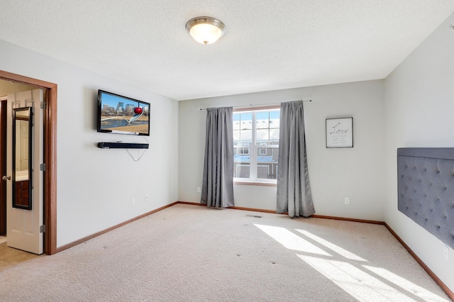 carpeted empty room with visible vents, baseboards, and a textured ceiling