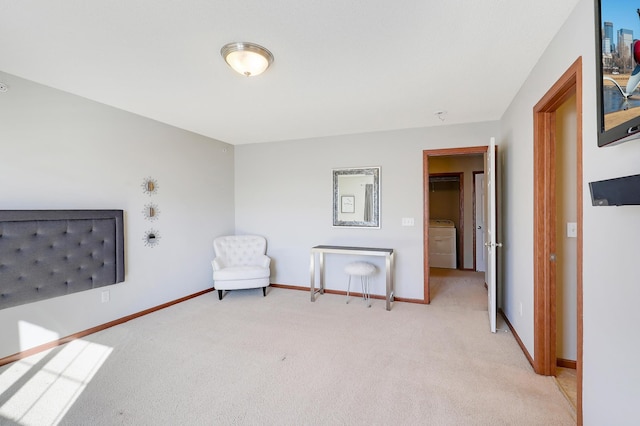 unfurnished room featuring washer / clothes dryer, light colored carpet, and baseboards