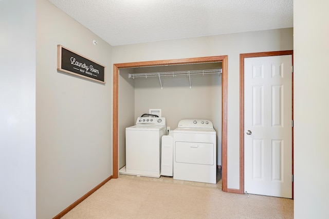 laundry room featuring light colored carpet, a textured ceiling, and independent washer and dryer