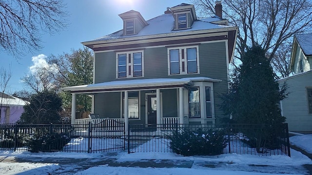 traditional style home featuring a fenced front yard and covered porch