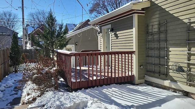 snow covered deck featuring fence