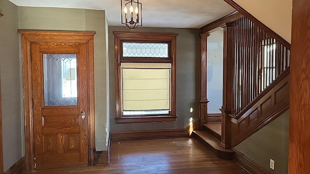 entrance foyer featuring baseboards, stairway, ornate columns, and wood finished floors