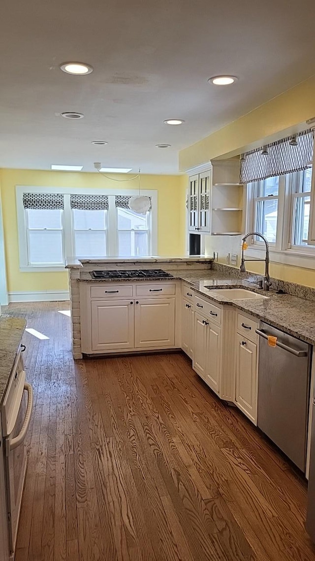 kitchen with white cabinets, dishwasher, dark wood-style floors, open shelves, and a sink