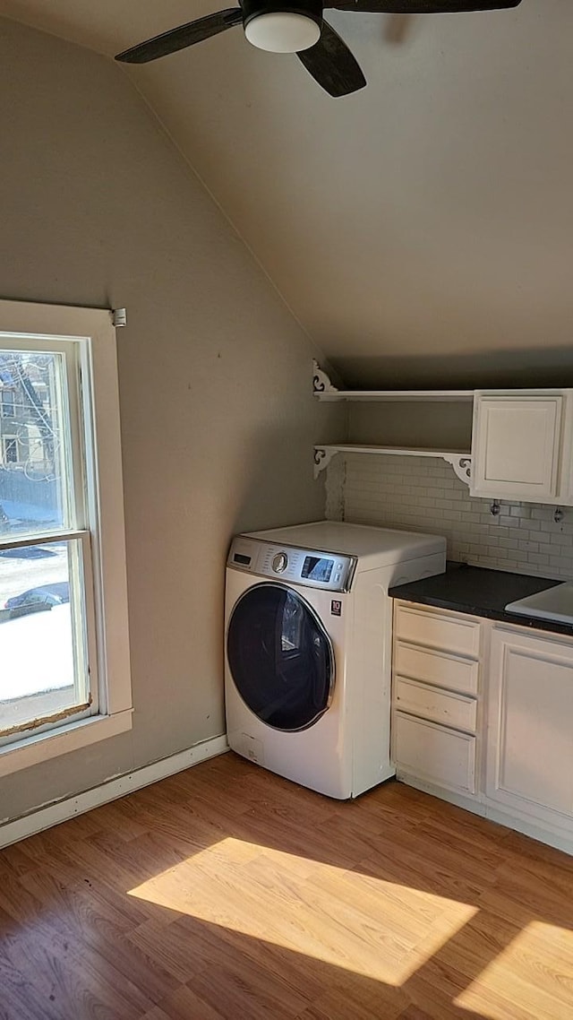 laundry area featuring cabinet space, light wood-style flooring, a ceiling fan, washer / dryer, and baseboards