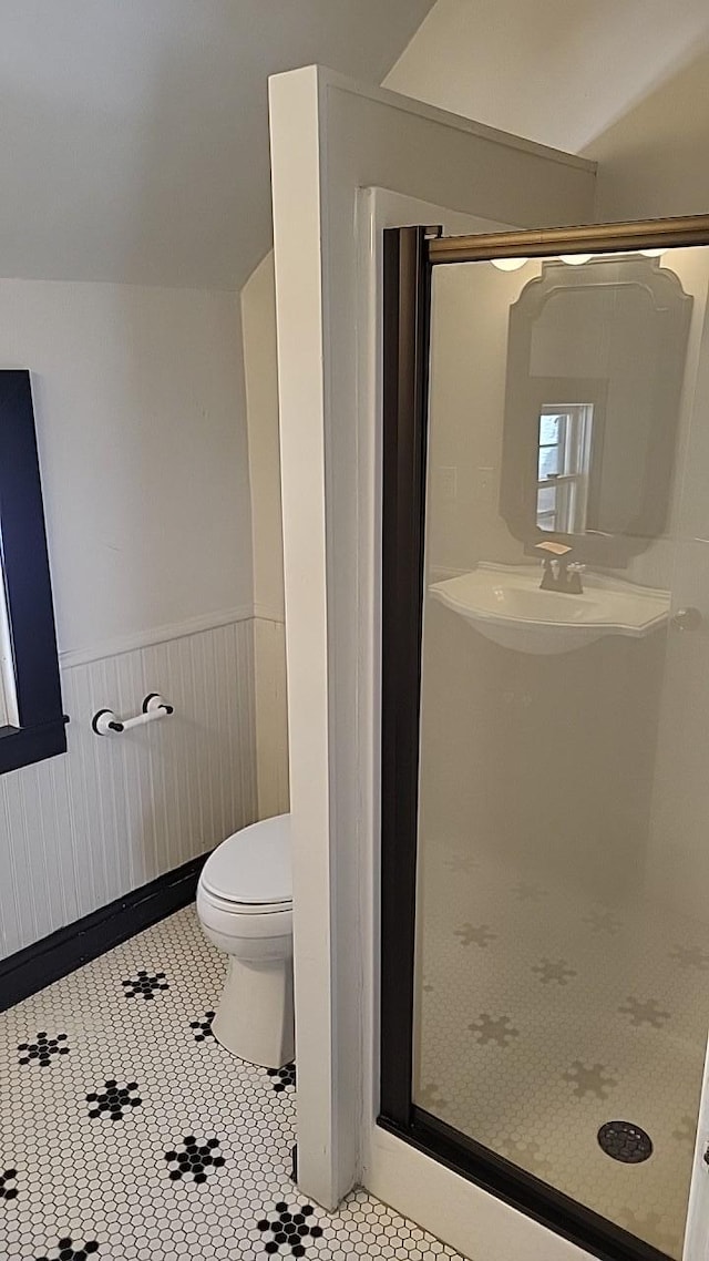 bathroom featuring a shower stall, tile patterned flooring, and wainscoting