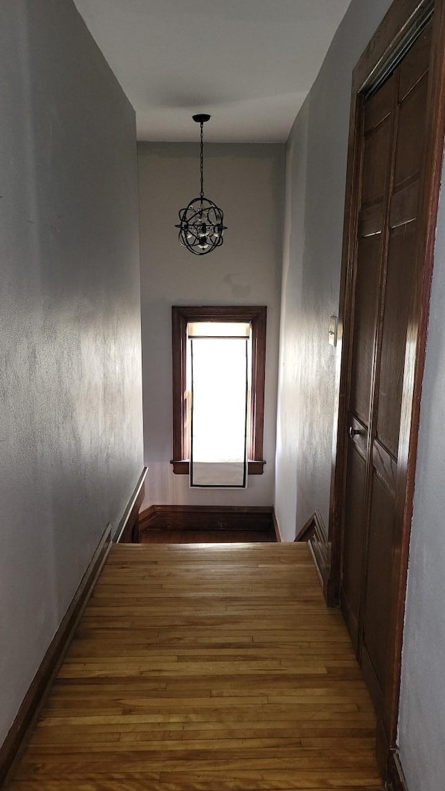 hallway with baseboards and wood finished floors