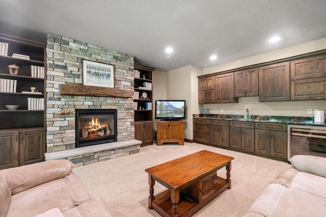 4350 Golfview Dr, Jordan, MN 55352 - living room featuring wine cooler, light carpet, a stone fireplace, recessed lighting, and a textured ceiling