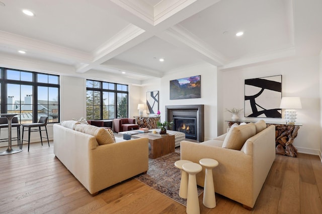 living room with light wood finished floors, coffered ceiling, a glass covered fireplace, beamed ceiling, and recessed lighting