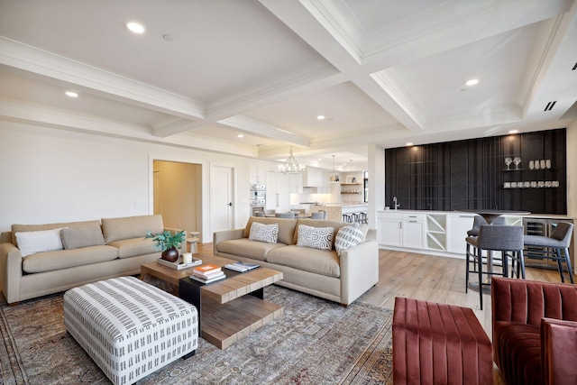 living room featuring recessed lighting, a notable chandelier, coffered ceiling, light wood-type flooring, and beamed ceiling