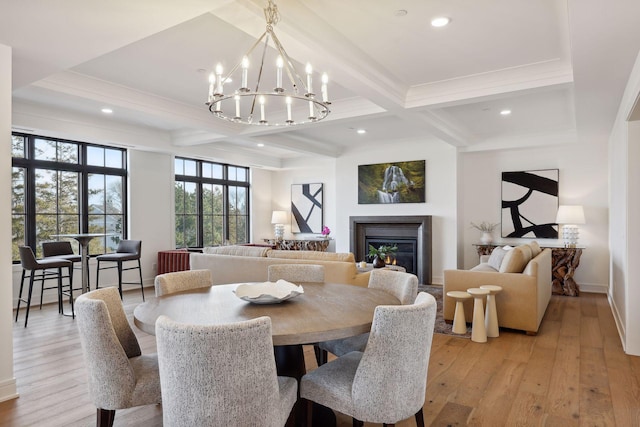 dining area with coffered ceiling, a glass covered fireplace, light wood-style flooring, beamed ceiling, and recessed lighting