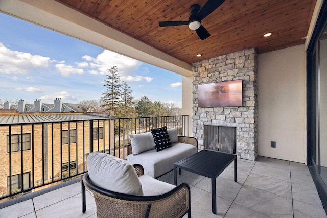 balcony featuring an outdoor stone fireplace and a ceiling fan