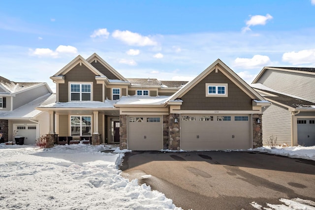 view of front facade featuring stone siding and aphalt driveway