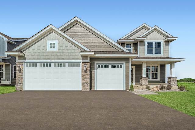 craftsman inspired home with a garage, stone siding, and aphalt driveway