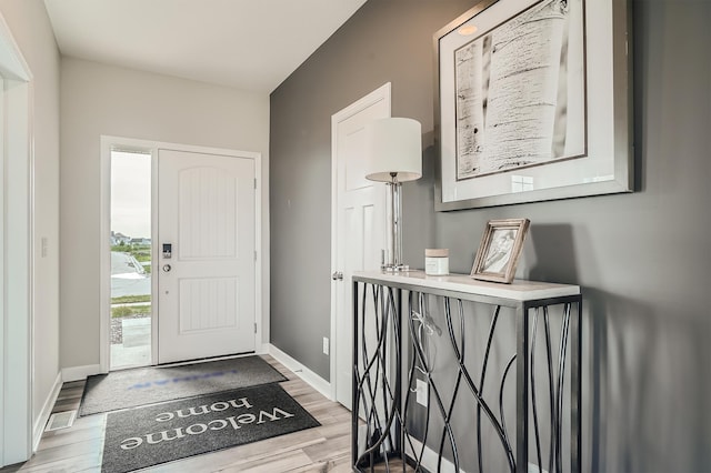 foyer with light wood-style flooring and baseboards