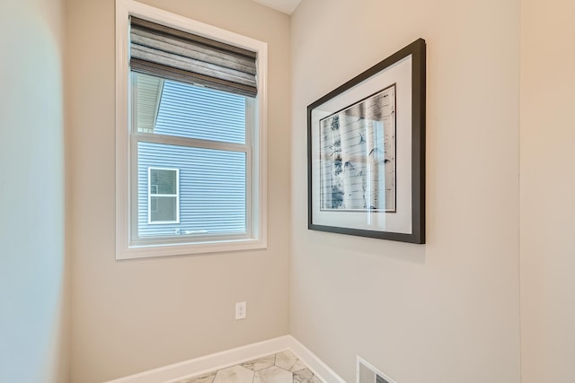 unfurnished room featuring marble finish floor, visible vents, and baseboards