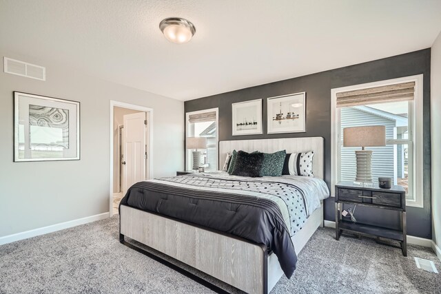 bedroom featuring carpet floors, visible vents, and baseboards