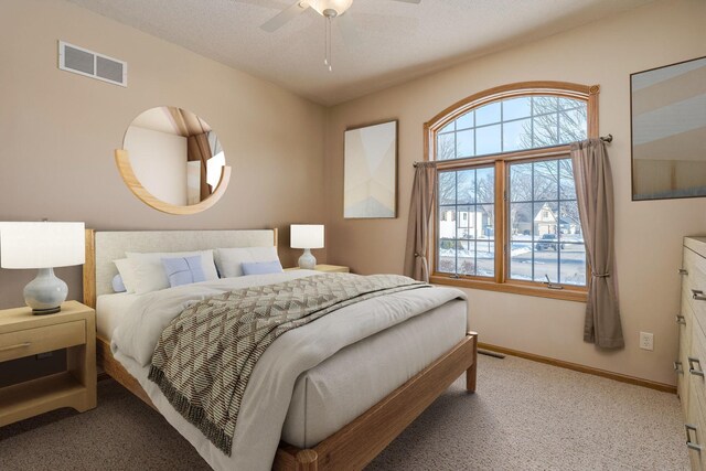 bedroom featuring light carpet, ceiling fan, visible vents, and baseboards