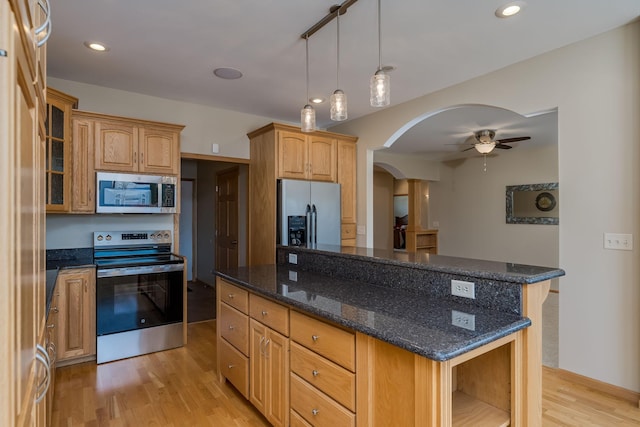 kitchen featuring arched walkways, appliances with stainless steel finishes, a center island, light wood-type flooring, and open shelves