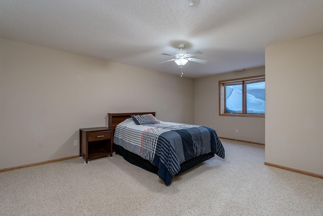 carpeted bedroom featuring a ceiling fan, baseboards, and a textured ceiling