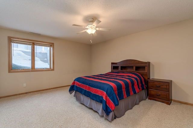 bedroom featuring a textured ceiling, ceiling fan, carpet, and baseboards