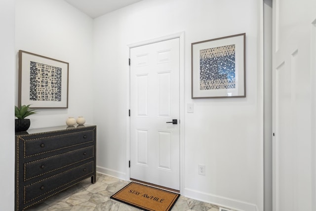 entryway featuring marble finish floor and baseboards