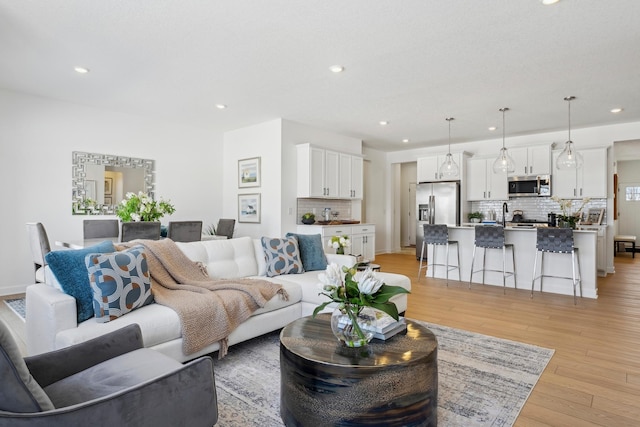 living room with light wood-type flooring and recessed lighting