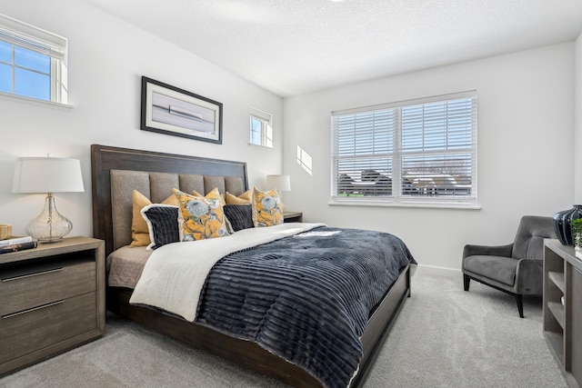 carpeted bedroom with a textured ceiling and baseboards