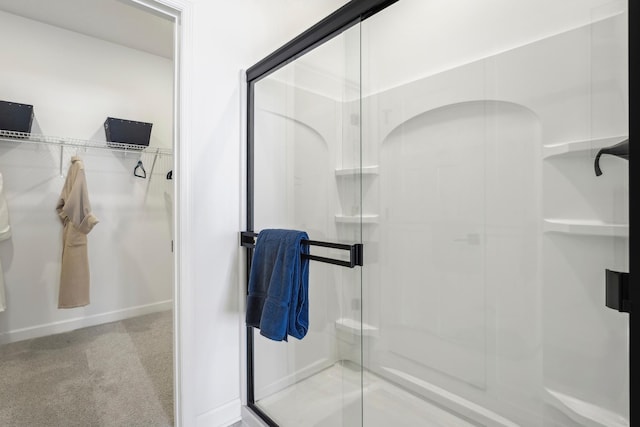 bathroom with a stall shower and a walk in closet