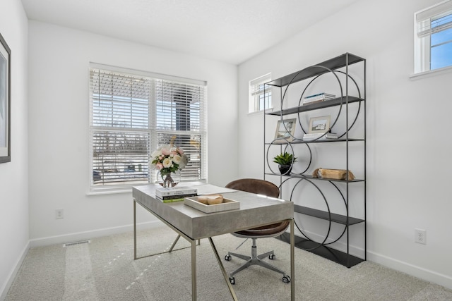 carpeted office space featuring plenty of natural light, visible vents, and baseboards