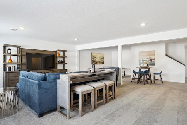 living area with recessed lighting, light colored carpet, a textured ceiling, and baseboards