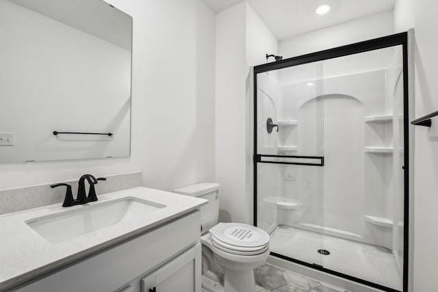 bathroom with toilet, a shower stall, and vanity