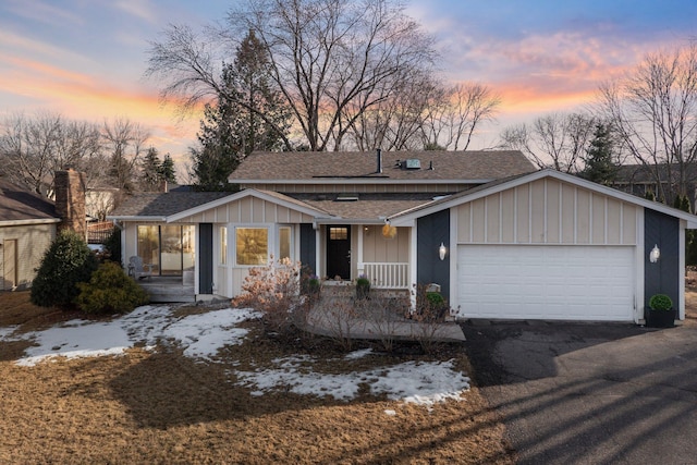 view of front of house featuring a porch, a shingled roof, a garage, aphalt driveway, and board and batten siding