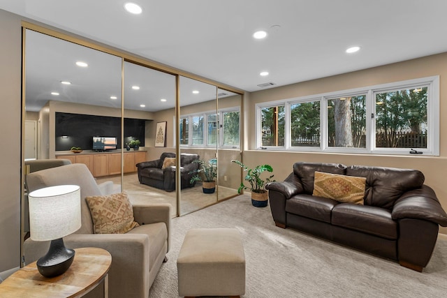 carpeted living area featuring visible vents and recessed lighting