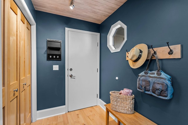 foyer entrance with rail lighting, baseboards, wood finished floors, and wooden ceiling