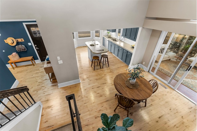 living room featuring stairway, baseboards, and light wood finished floors