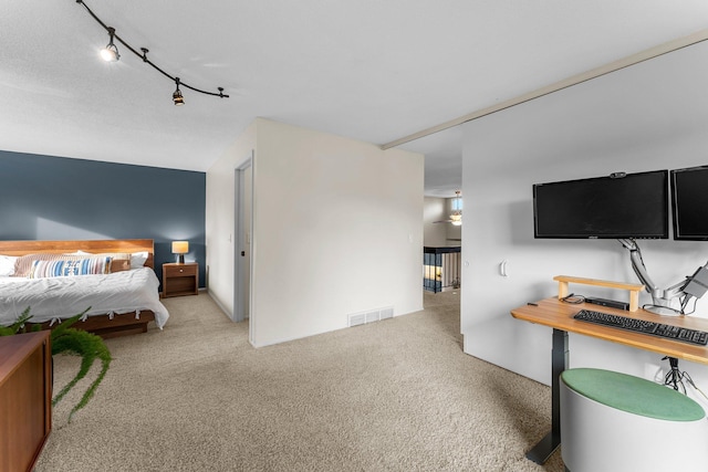 carpeted bedroom featuring visible vents and rail lighting