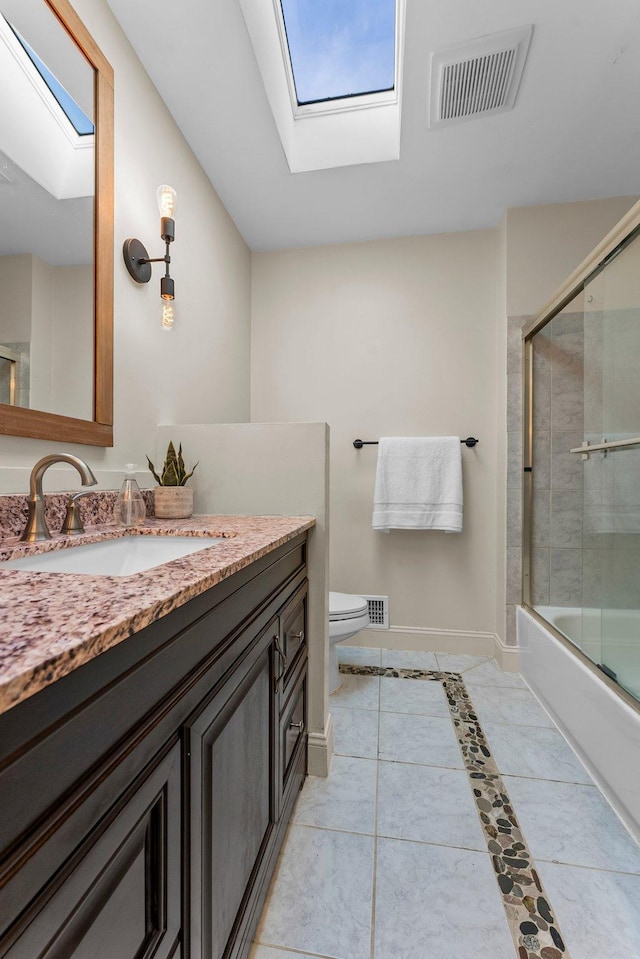 bathroom featuring vanity, a skylight, baseboards, and visible vents