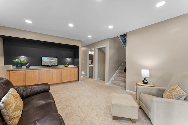 living room with recessed lighting, baseboards, light colored carpet, and stairs