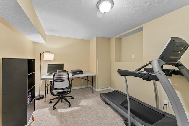 exercise room featuring baseboards, carpet, and a textured ceiling